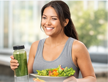 Woman holding a green smoothie and salad